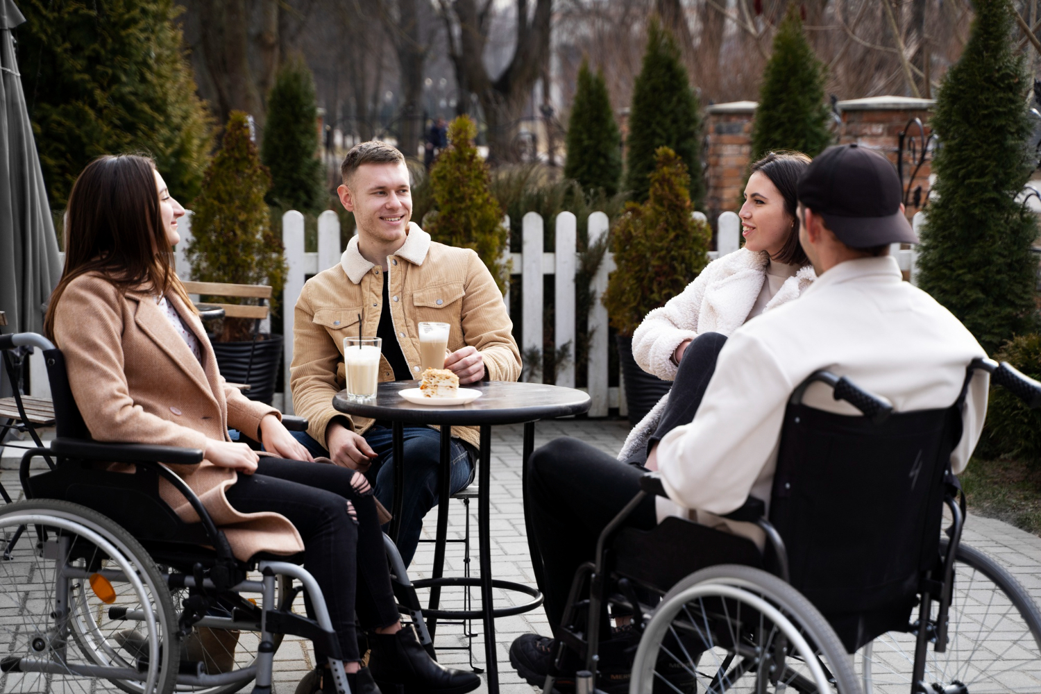 NDIS participants and a Wellness Care support worker socialising together in a community setting in Melbourne.